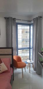a room with a bed and a window with a chair at Grand Riviera Suites, US Embassy Comfy, Affordable Studio in Roxas Blvd, Ermita Manila in Manila