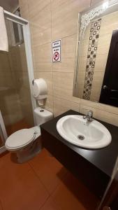 a bathroom with a white toilet and a sink at Hostal la perla del sur in Quito