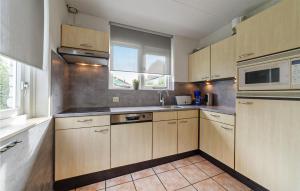 a kitchen with wooden cabinets and a window at Oesterbaai 8 Personen in Wemeldinge