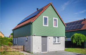 ein grünes und weißes Haus mit einer Garage in der Unterkunft Oesterbaai 8 Personen in Wemeldinge