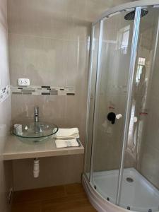 y baño con lavabo de cristal y ducha. en Room in Bungalow - Loft Del Fundo Del Abuelo, en Cajamarca