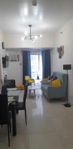- un salon avec un canapé bleu et une table dans l'établissement US Embassy Roxas Blvd, Ermita, Manila 1 Bedroom ComfySuite, à Manille