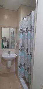 a bathroom with a sink and a shower curtain at US Embassy Roxas Blvd, Ermita, Manila 1 Bedroom ComfySuite in Manila