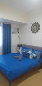 - un grand lit bleu avec des draps et des oreillers bleus dans l'établissement US Embassy Roxas Blvd, Ermita, Manila 1 Bedroom ComfySuite, à Manille