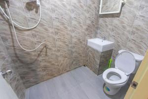 a small bathroom with a toilet and a shower at The Travelers Friend En Suite dorm room AC in Ban Ai Dao