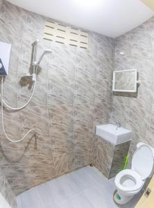 a bathroom with a shower and a toilet and a sink at The Travelers Friend En Suite dorm room AC in Ban Ai Dao