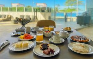 una mesa cubierta con platos de desayuno y zumo de naranja en Hotel Nacional en Río de Janeiro
