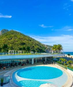 a pool at a resort with the ocean in the background at Hotel Nacional in Rio de Janeiro
