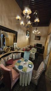 uma sala de jantar com mesas e cadeiras e um lustre em Riad La Porte du Bouregreg em Salé