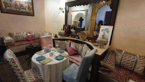 sala de estar con mesa y espejo en Riad La Porte du Bouregreg en Salé