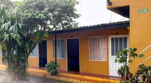 a yellow and blue house with a blue door at LA AVENIDA ALOJAMIENTO in Guaduas
