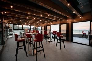 un bar con sillas rojas y vistas al océano en The Ocean House en Shimen