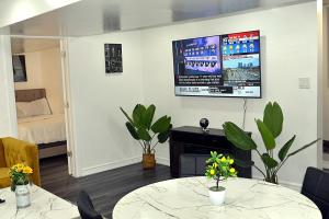 DIAMOND PLACE في برامبتون: غرفة معيشة مع طاولة وتلفزيون على الحائط
