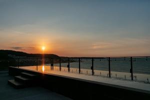 a sunset over the water with a pier at The Ocean House in Shimen District