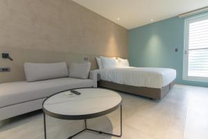 石門區的住宿－半島海悅渡假會館，一间带沙发、床和桌子的卧室