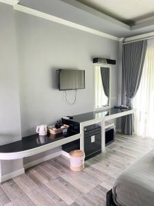 Dormitorio con escritorio, cama y TV en Blues River Resort, en Chao Lao Beach