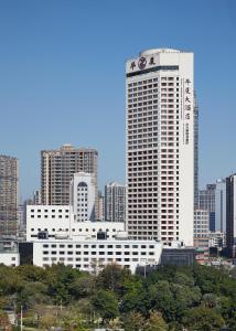 فندق لاندمارك كانتون في قوانغتشو: مبنى أبيض كبير في مدينة ذات مباني طويلة
