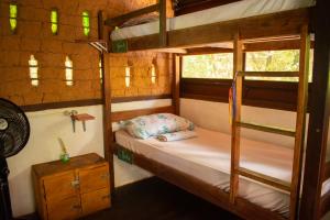 a bedroom with two bunk beds and a night stand at Lagarto Na Banana Hostel in Pipa