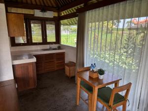 a kitchen with a table and a sink and a window at GRIYA KCB VILLA in Ubud