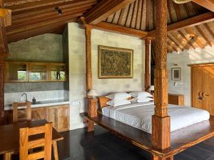 a bedroom with a large bed and a sink at GRIYA KCB VILLA in Ubud