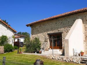 una casa in pietra con una porta in legno in un cortile di Holiday Home in Haute-Vienne near Nature Park a Les Salles-Lavauguyon