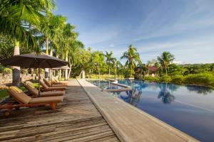 - une piscine avec des chaises et un parasol à côté du complexe dans l'établissement El Jardin de Zaida Managed by HII, à San Juan