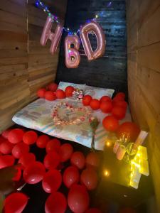 un pastel de cumpleaños con un signo B y globos rojos en Posada Tipiland la casa del Mono en Playa Blanca