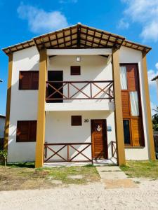 a white house with a brown door at Chalé Nautic Atins in Atins +35 photos