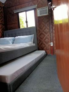 a bed in a room with a window at JHULLIE’S BREEZY HUT in Tagaytay