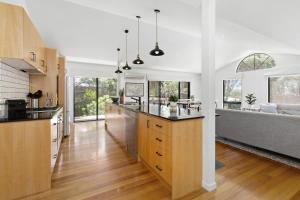 ライにあるBack Beach Retreat - Dual Living Accommodation in Ryeの白い壁とウッドフロアのキッチン(窓付)