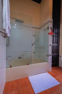 a bathroom with a shower with a glass shower backdoor at Hotel Casa Bansley in Antigua Guatemala