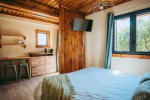 ein Schlafzimmer mit einem Bett und einer Küche darin in der Unterkunft L'Auberge Créole in Saint-Benoît