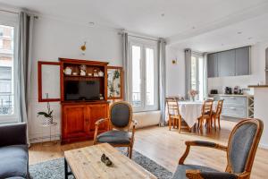 a living room with a table and a kitchen at Charming flat in Boulogne-Billancourt - Welkeys in Boulogne-Billancourt