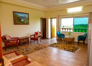 a living room with furniture and a large window at Lumbini Five Elements Hotel in Rummindei