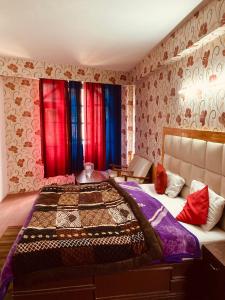 1 dormitorio con 1 cama grande y cortinas rojas y azules en Sandhu Farm House en Chandigarh
