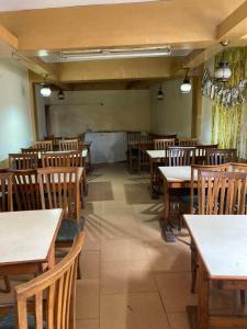 an empty restaurant with wooden tables and chairs at Sandhu Farm House in Chandīgarh