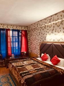 a bedroom with a large bed with red pillows at Sandhu Farm House in Chandīgarh