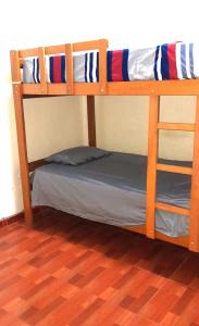 two bunk beds in a room with a bed at Hospedaje Arana in Chincha Alta