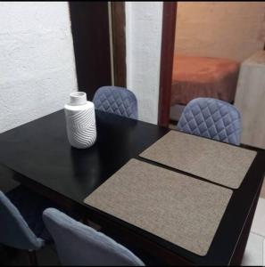 einem schwarzen Tisch mit zwei Stühlen und einer Vase darauf in der Unterkunft Minimalist House 1br El Bosque in Quito