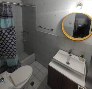 a bathroom with a toilet and a sink and a mirror at Minimalist House 1br El Bosque in Quito