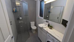 a bathroom with a shower and a toilet and a sink at Hatbox House in Perth