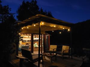 a gazebo with lights and chairs on a deck at night at Cabaña espectacular, con vista al río y hot tub privado in Linares