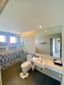 a bathroom with a toilet and a sink and a mirror at Palm Galleria Resort in Khao Lak