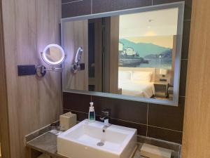 a bathroom with a sink and a large mirror at Atour Hotel Hefei Ma'anshan Road in Hefei