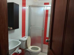 a bathroom with a toilet and a sink and a shower at Alojamiento villa maría in Coveñas