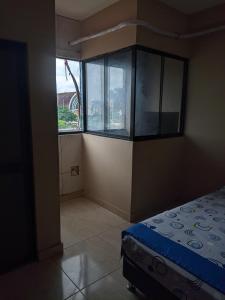 プカルパにあるDEPARTAMENTOS SUCRE PCLのベッド1台と大きな窓が備わる客室です。