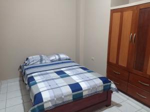 プカルパにあるDEPARTAMENTOS SUCRE PCLのベッドルーム1室(ベッド1台付)、木製キャビネットが備わります。
