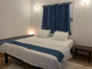 1 dormitorio con 1 cama con cortina azul en Ales & Juli, en Morjim