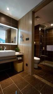 a bathroom with a sink and a toilet and a mirror at Atour Hotel Hefei Ma'anshan Road in Hefei