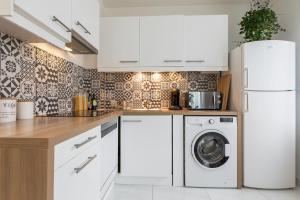 a kitchen with a washing machine and a washer and dryer at Beautiful and bright T2 in Villeurbanne near Lyon - Welkeys in Villeurbanne